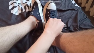 Schöne Beine in Turnschuhen auf dem Bett